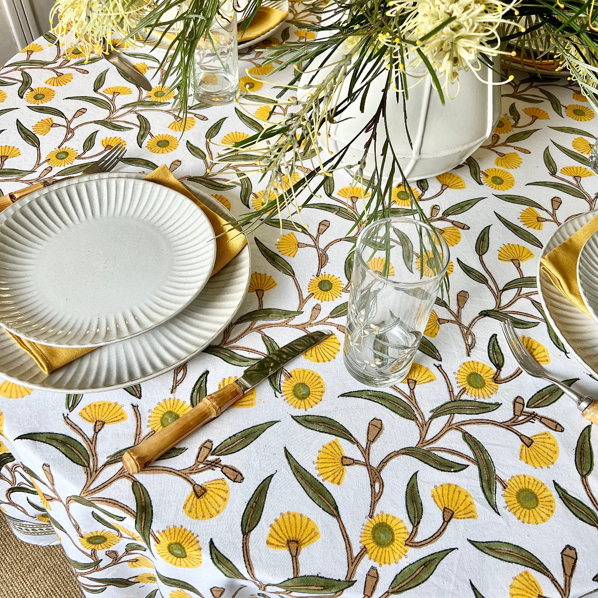 Hand block printed circular tablecloth featuring Australian native yellow green gums floral pattern on cotton.