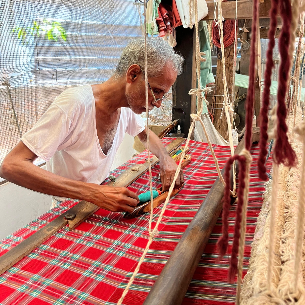 Artisan weaving Red Tartan Fabric on handloom