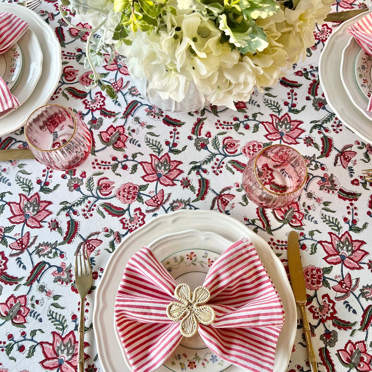 Top view of a large 220 x 220 cm Chintz multicoloured hand block printed cotton square tablecloth for an 8 seater table, a bold and vibrant dining linen for special occasion entertaining and festive celebrations.