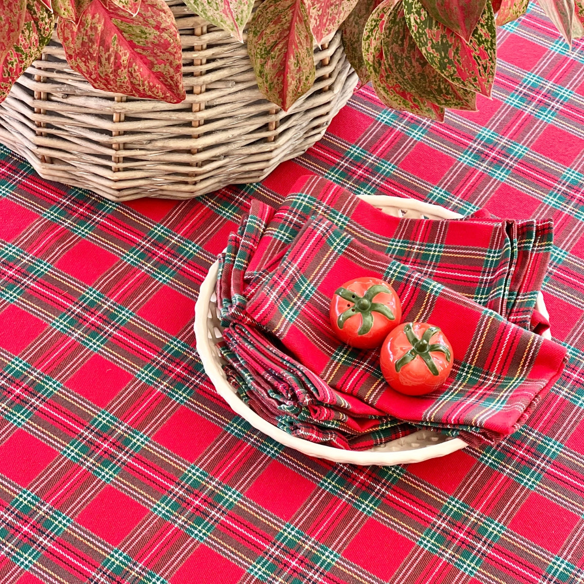 Red plaid napkin set in a basket with tomatoes on a matching plaid tablecloth