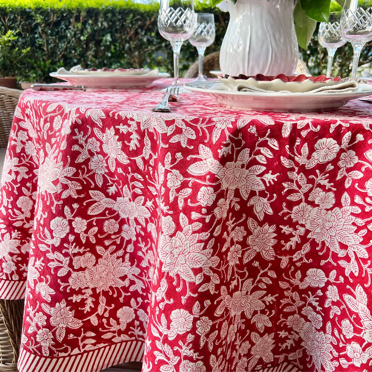 Circular table linen featuring a hand block printed red floral pattern