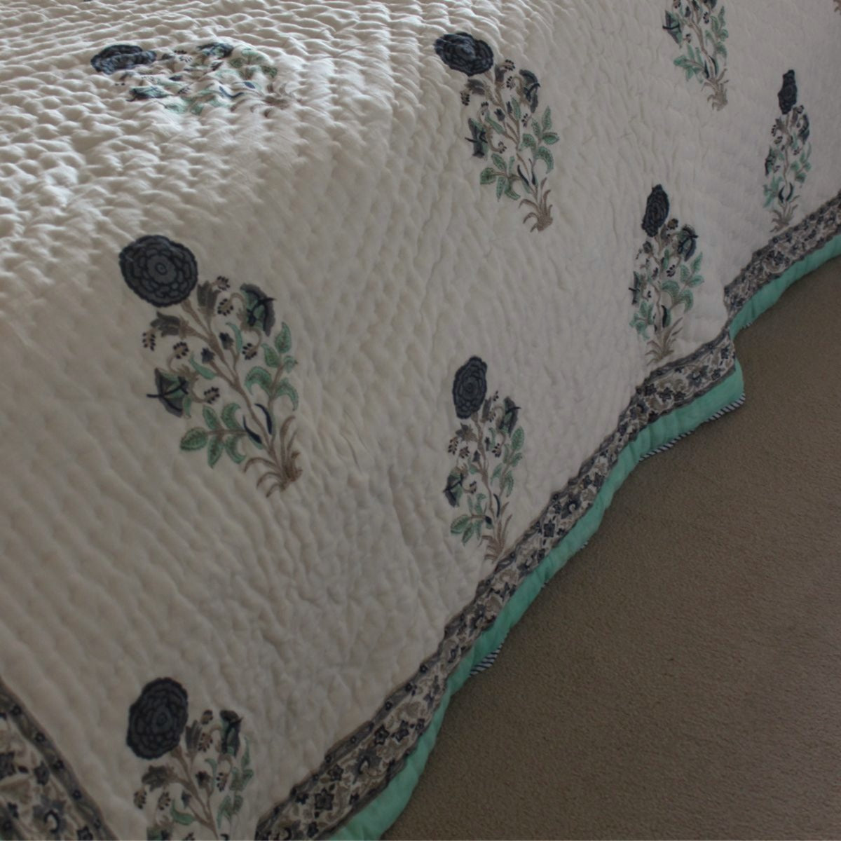 Floral patterned quilt on a bed with a beige background