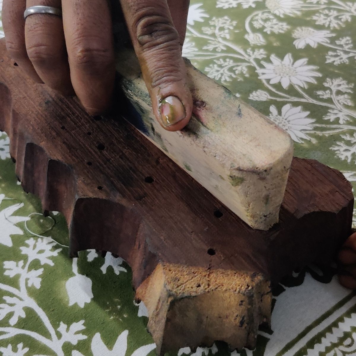 Indian artisan hand printing the Flannel Flowers square tablecloth using traditional block printing methods and carved wooden blocks.