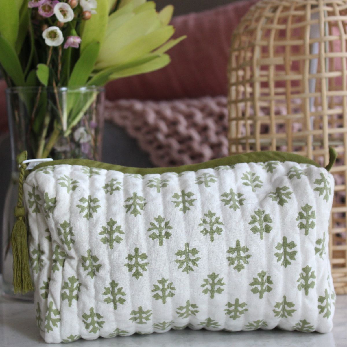 Hand block printed quilted toiletry bag in the Flannel Flowers pattern displayed on a tabletop, perfect for organizing beauty products and personal items.