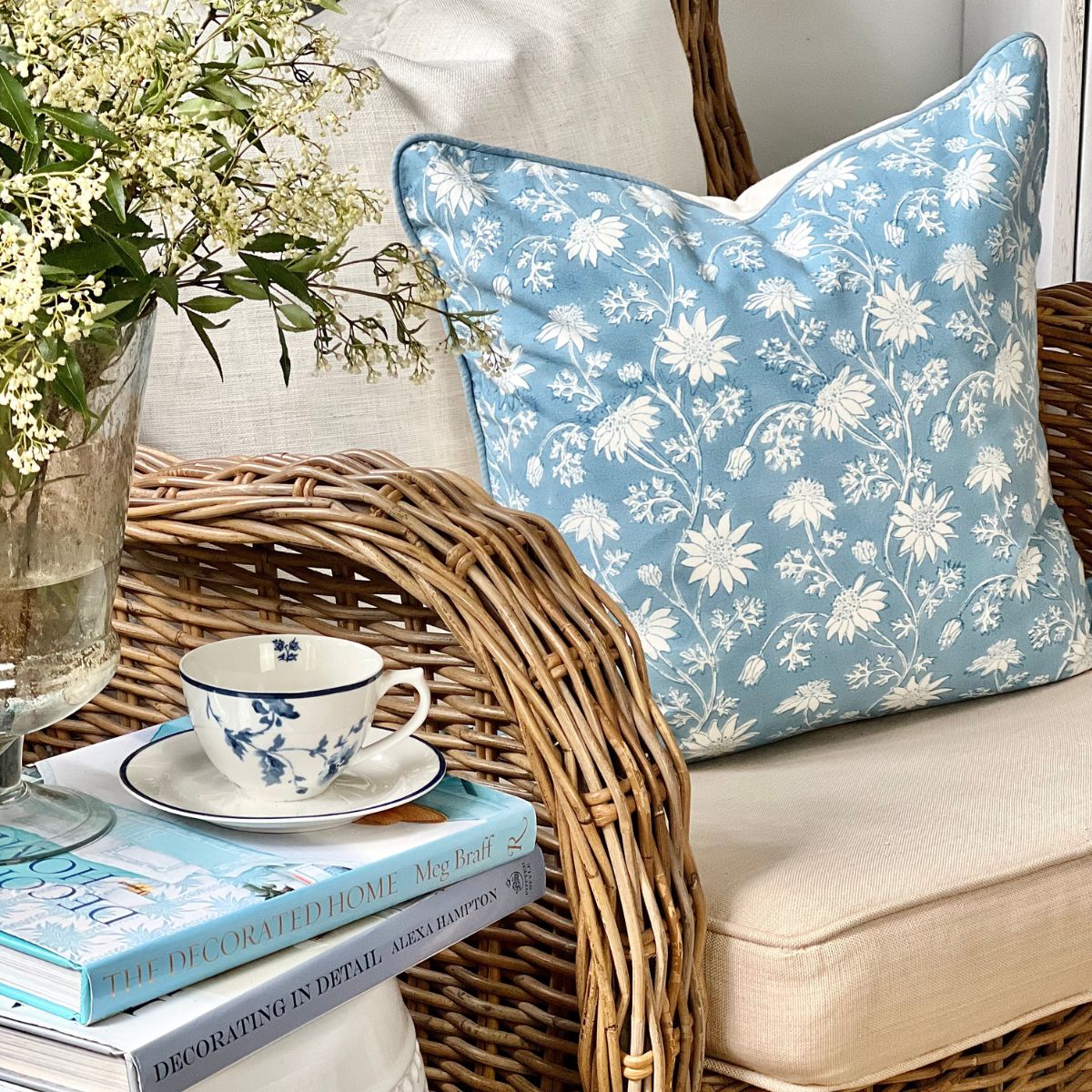 50 cm cotton cushion cover featuring Australian native flannel  floral pattern placed on a wicker chair, coffee corner.