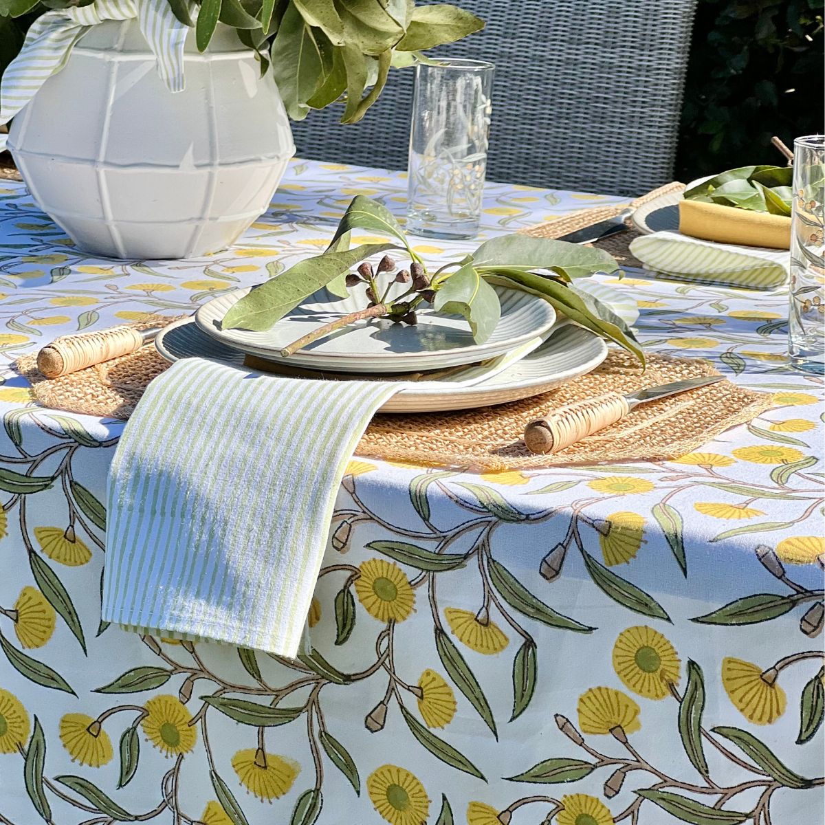 180 x 300 cm Yellow Flowering Gums tablecloth styled in a garden setting for a casual outdoor brunch with coordinated tableware.