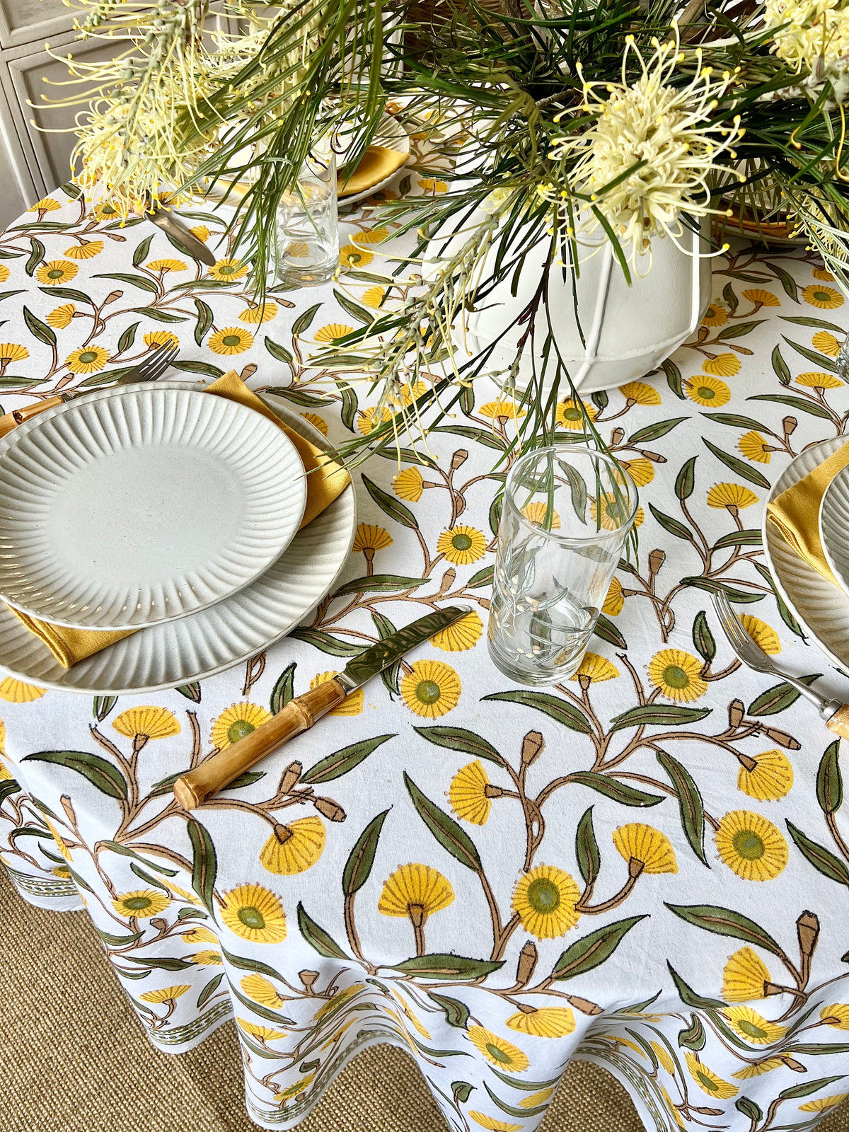 Hand block printed circular tablecloth featuring Australian native yellow green gums floral pattern on cotton. 