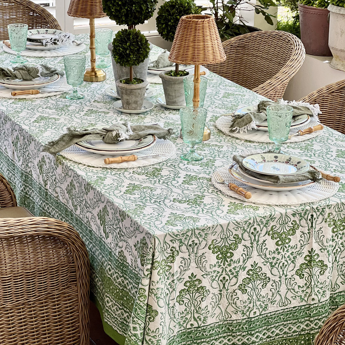 Long rectangular green hand block printed tablecloth in 180 x 340 cm styled with potted topiary and wicker chairs for a table of 10 to 12 guests