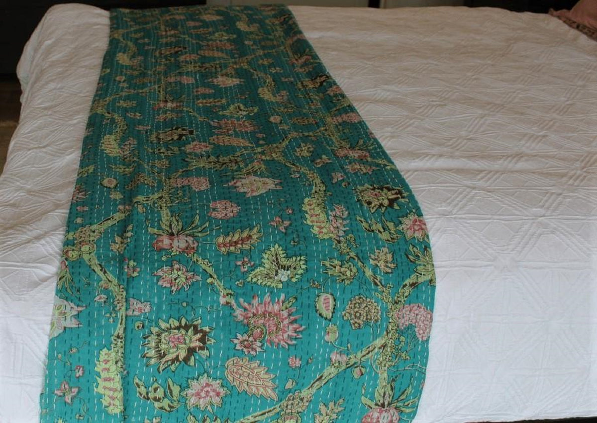 Floral-patterned quilt on a white bedspread