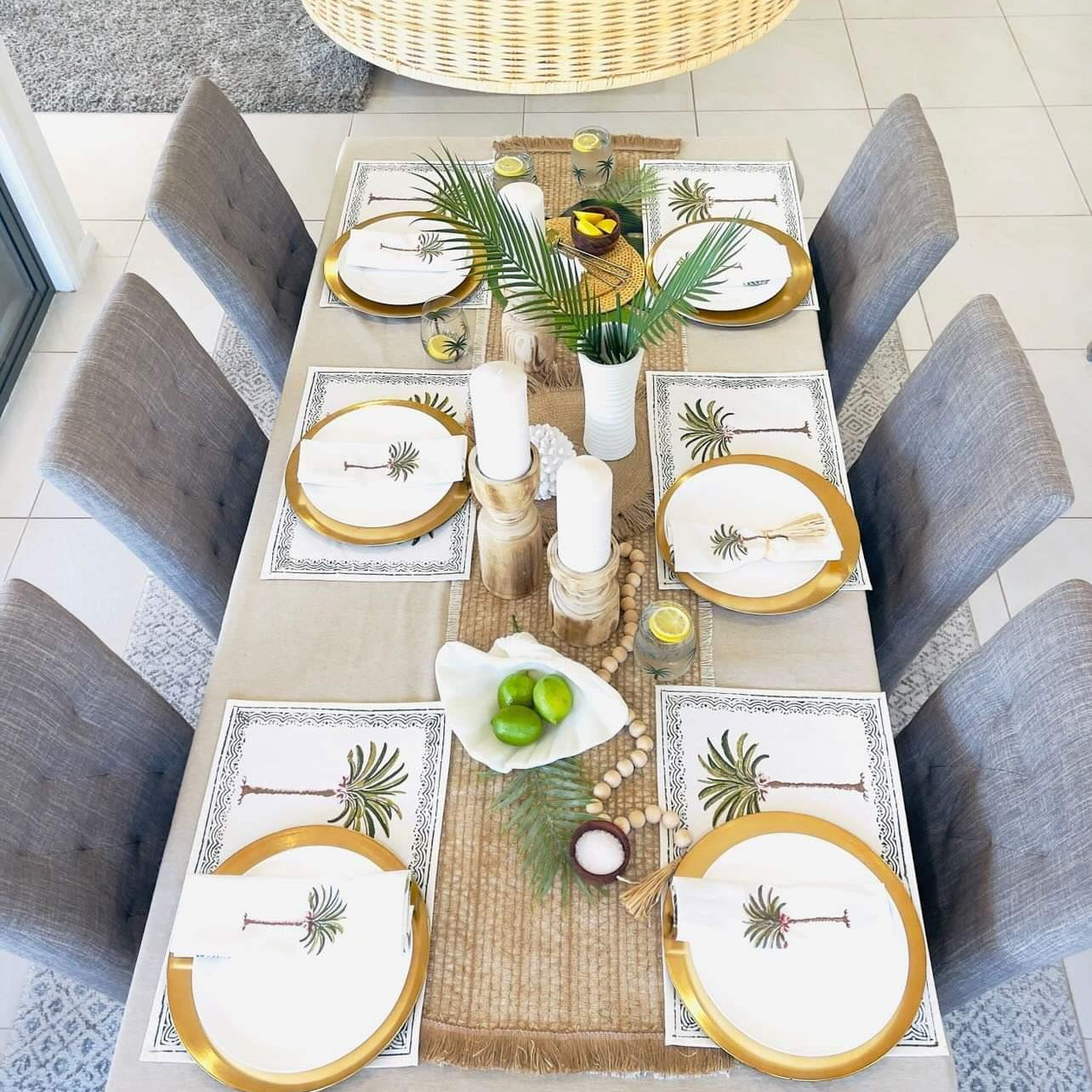 Dining table set with placemats, plates, and centerpieces in a home setting.