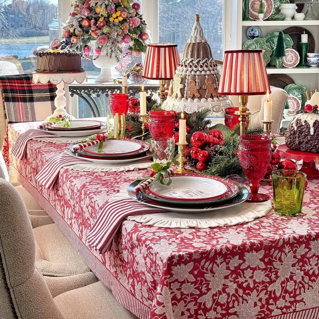 Red floral tablecloth set on a large table with decorative christmas accents for cozy family gathering