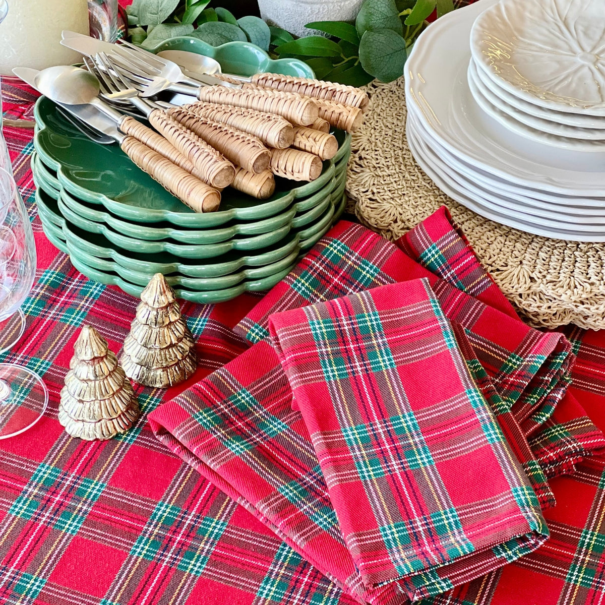 Set of four red tartan plaid cotton napkins styled for holiday dining.