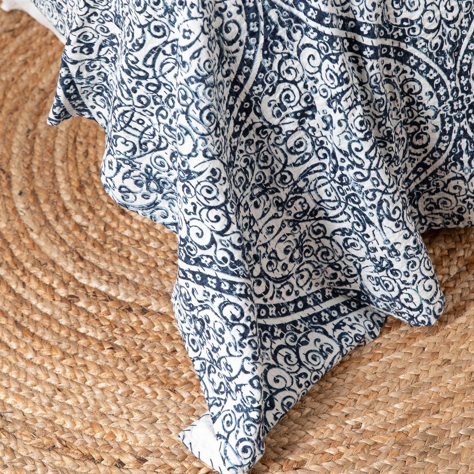 Bedroom with a bed covered in blue and white patterned bedding, surrounded by decorative elements.