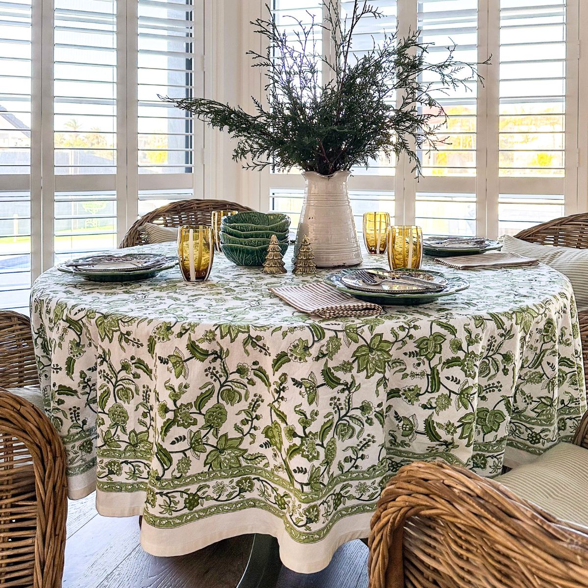 
A 180 cm Chintz monochrome green hand block printed cotton round tablecover for a 6 seater circular dining table, an elegant christmas table linen in rich green floral block print that brings freshness and artisan character to holiday meal.