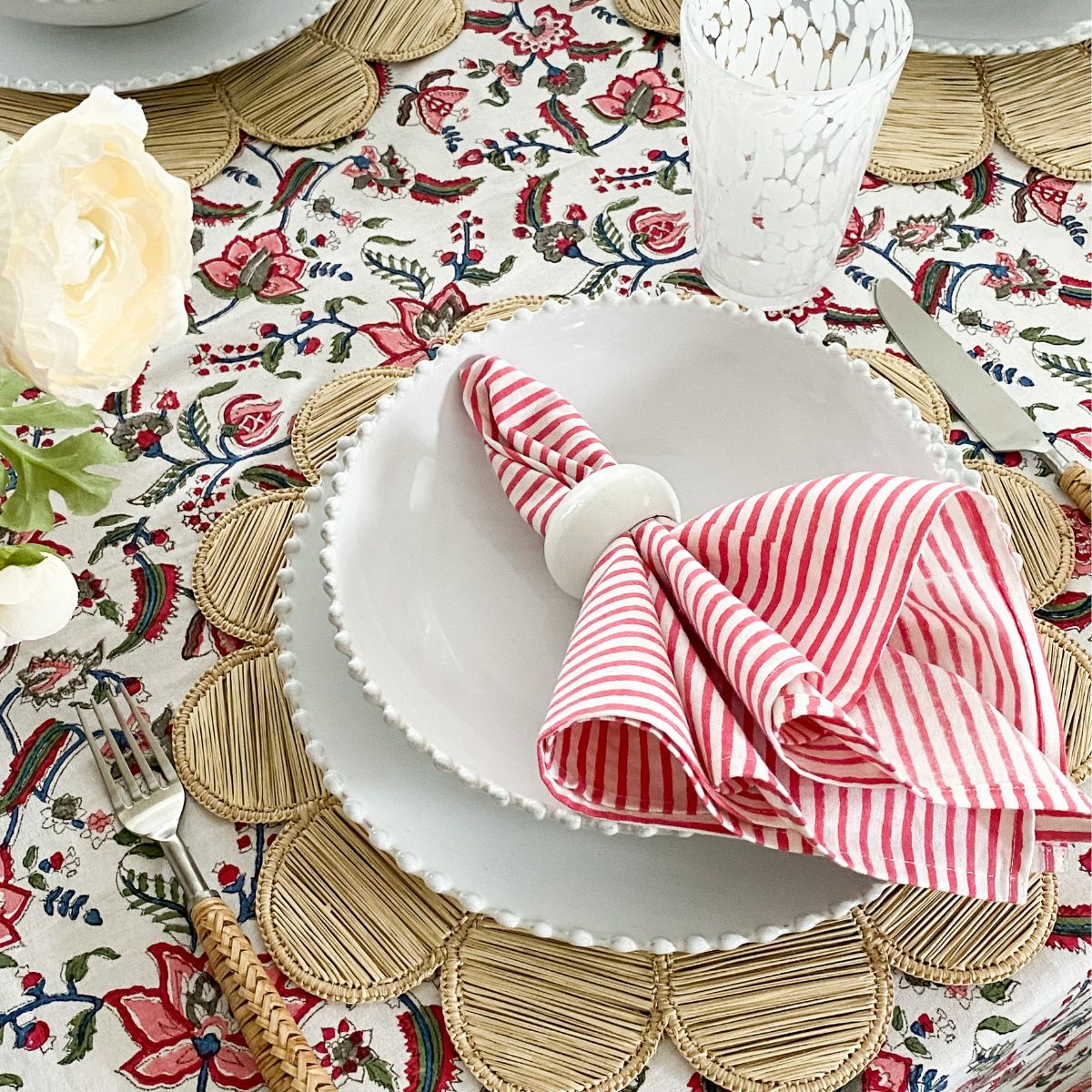 
A large 180 x 345 cm Chintz multicoloured hand block printed cotton tablecover with pink striped block printed napkins displayed on a 10 to 12 seater table, a showstopping special occasion dining linen in premium hand block printed cotton.
