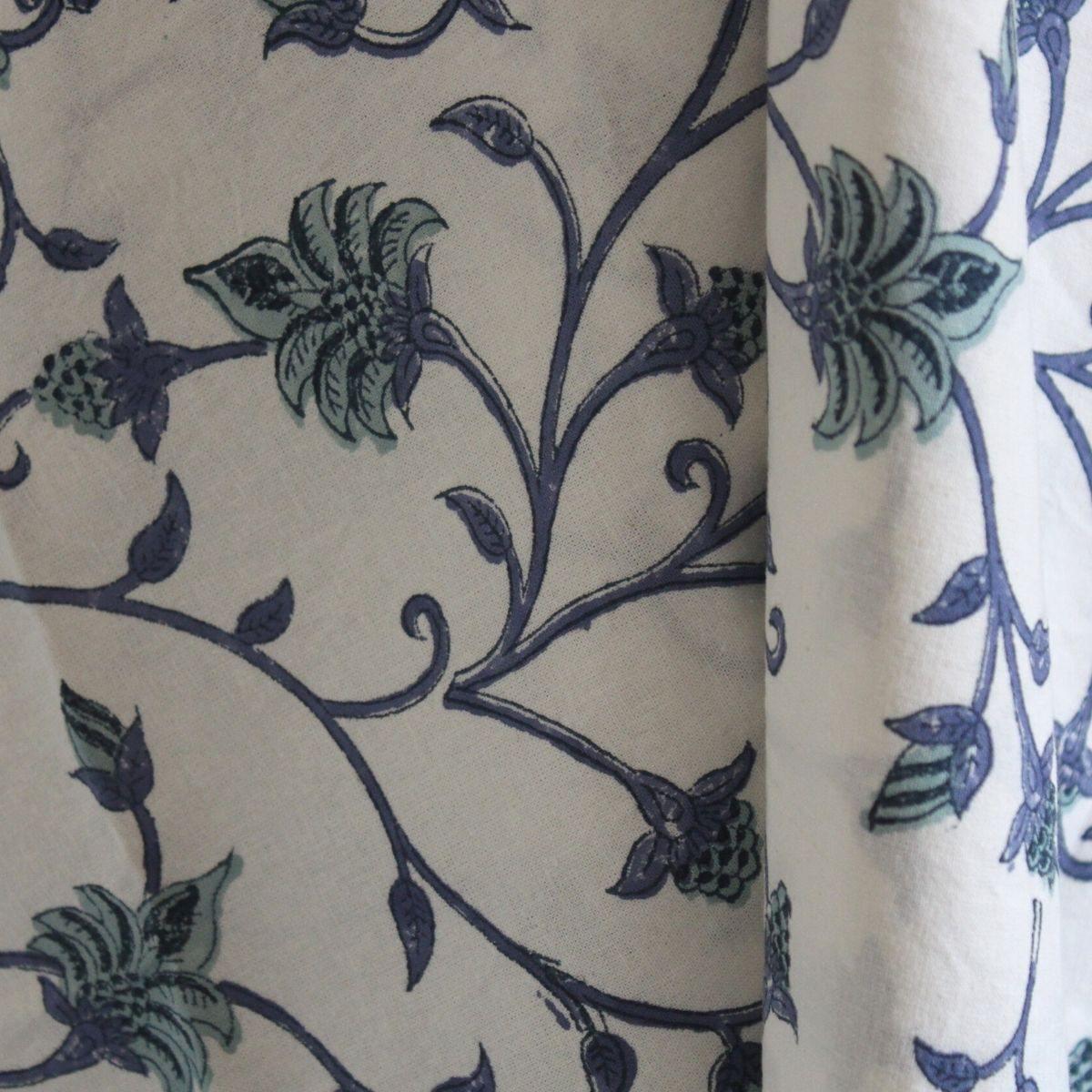 A close-up of a round blue and green Ivy hand block printed cotton tablecloth pattern