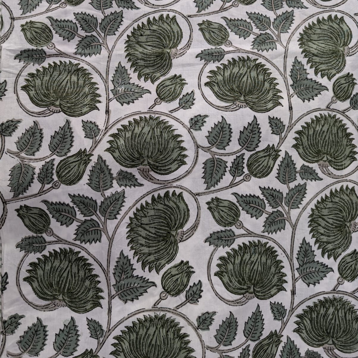 A close-up of the 220 cm green lotus hand block printed round tablecover, the intricate lotus motif and rich green tones of the hand block print.