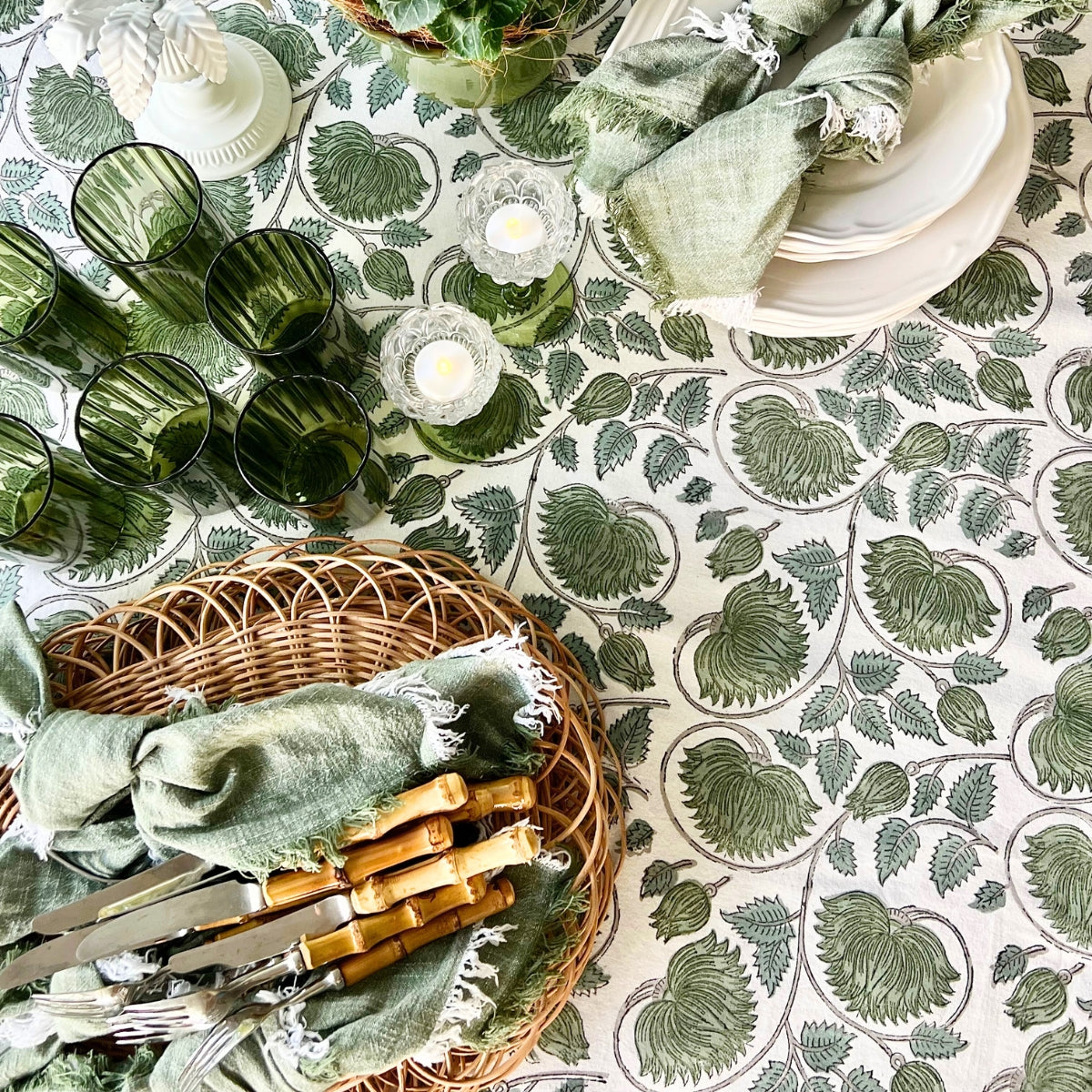 Hand Block printed cotton tablecloth draped on a large 8 seater dining table styled for a weekend brunch, featuring lotus floral pattern by skilled artisans in Jaipur India.