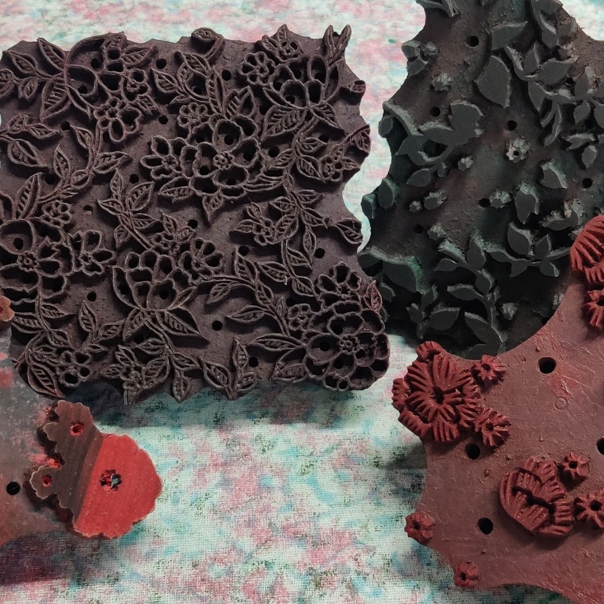 Decorative stamps with floral and leaf patterns on a textured surface