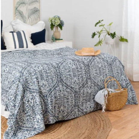 Bed with a patterned comforter in a bedroom setting