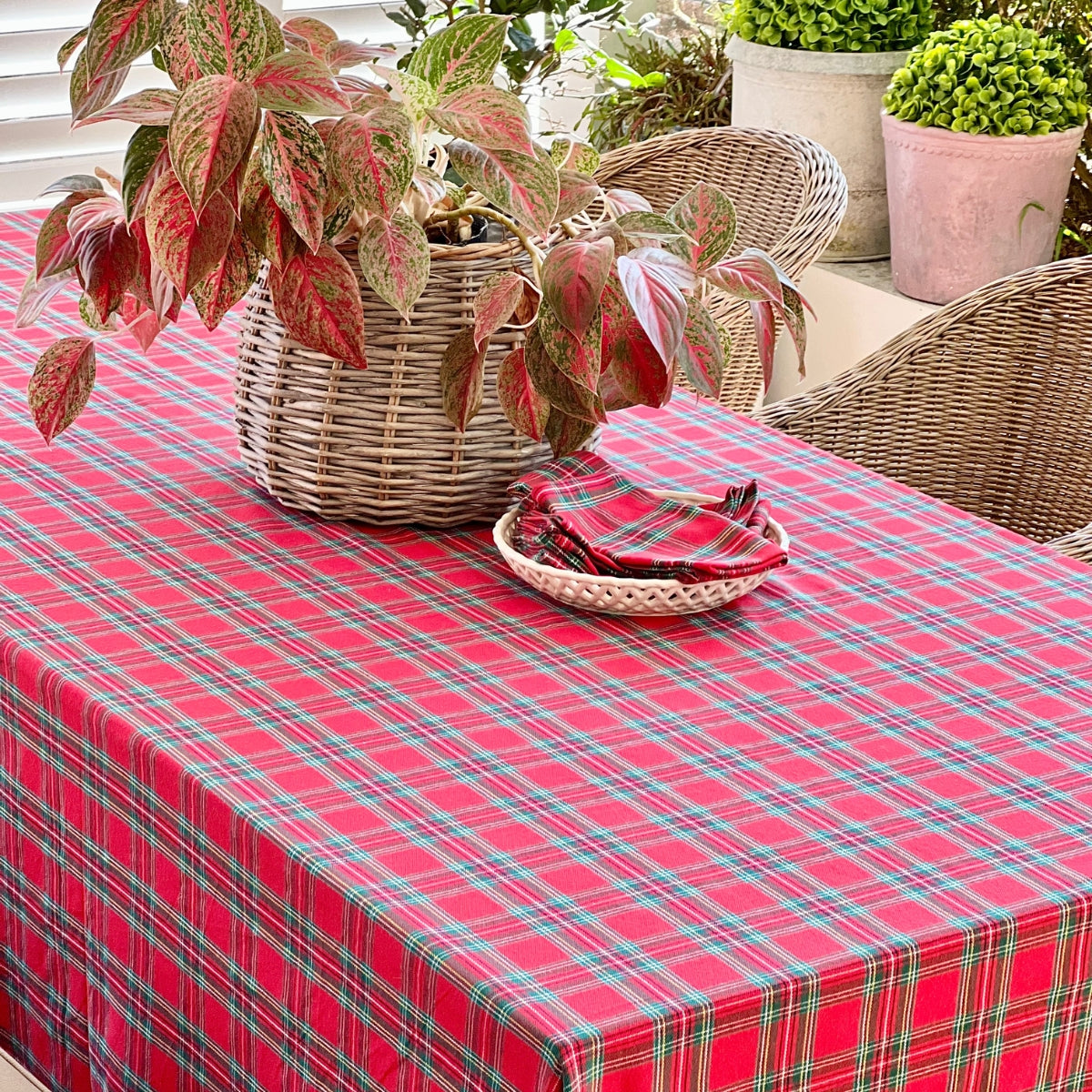 A square red tartan plaid handwoven table linen for a casual outdoor dining table, perfect for a relaxed alfresco brunch or any special gathering.
