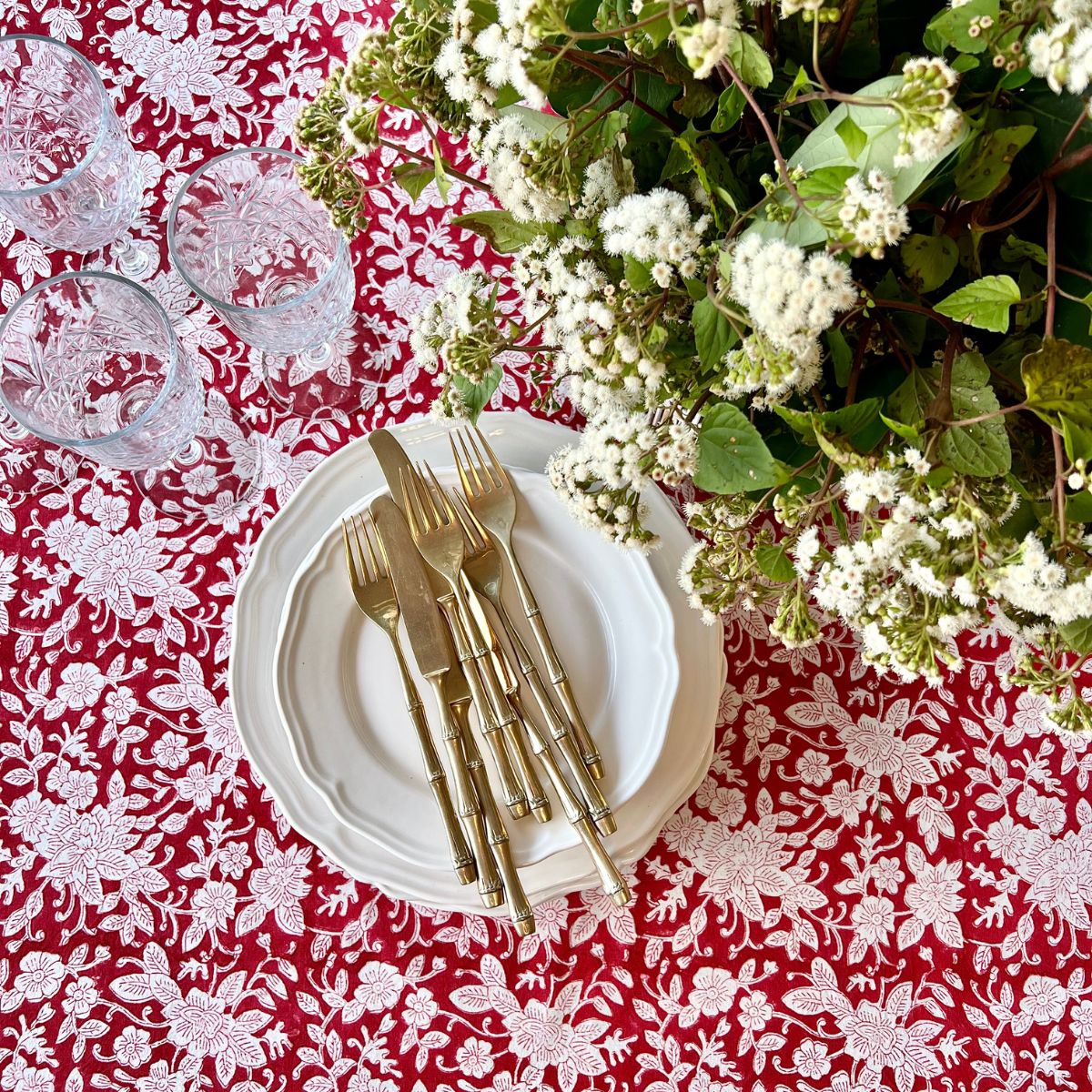 
A 220 x 220 cm red and white floral hand block printed cotton square tablecloth for an 8 seater table, a striking everyday dining linen for relaxed alfresco entertaining.