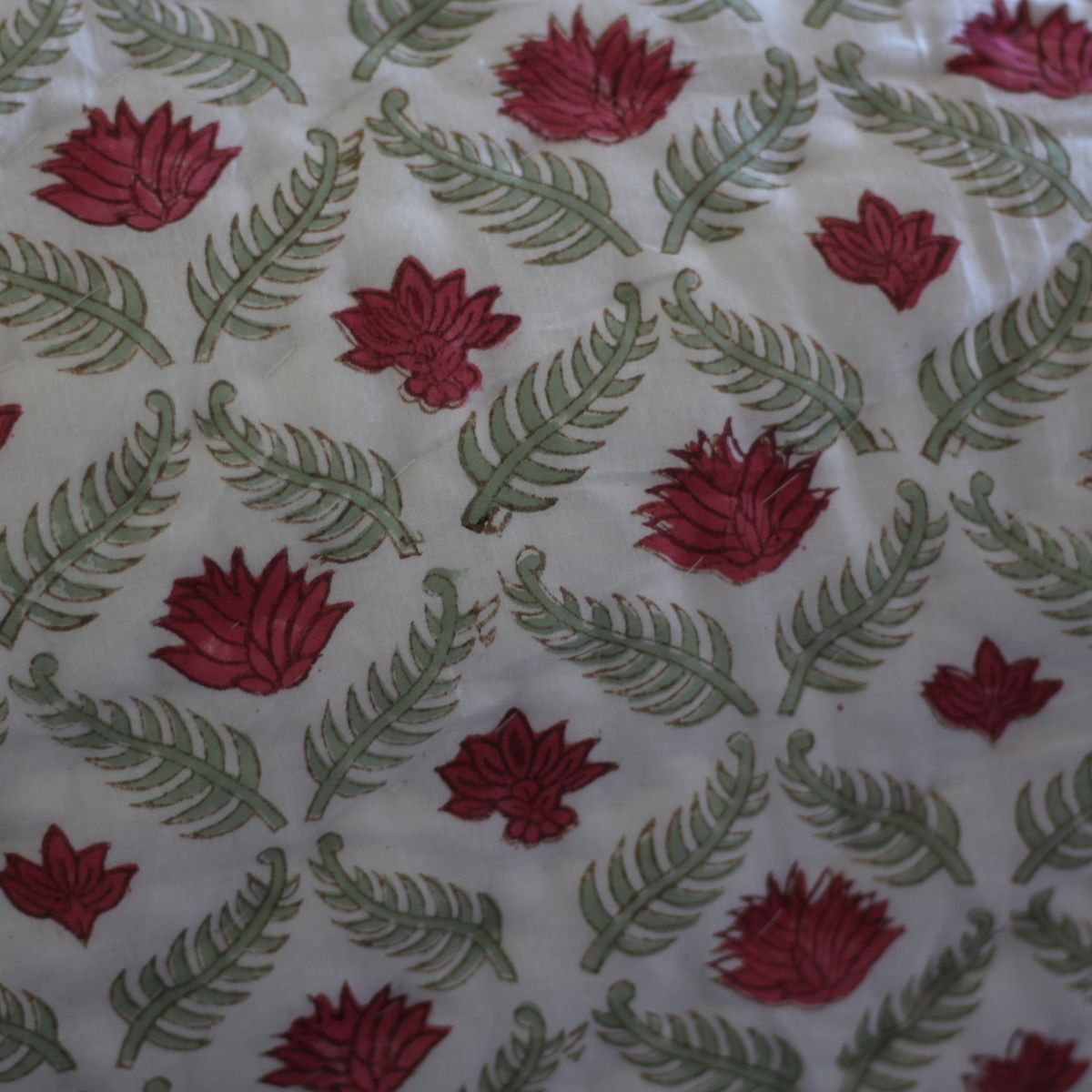 Close-up of Ruby reversible cotton quilt highlighting detailed floral block printing, hand quilting, and fine artisan craftsmanship.
