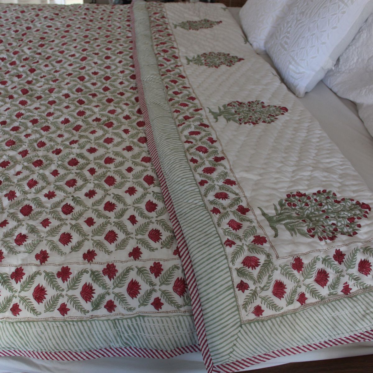 
Ruby red and green reversible cotton quilt featuring vintage-inspired floral block print motifs, handcrafted for timeless bedroom styling and all-season comfort.
