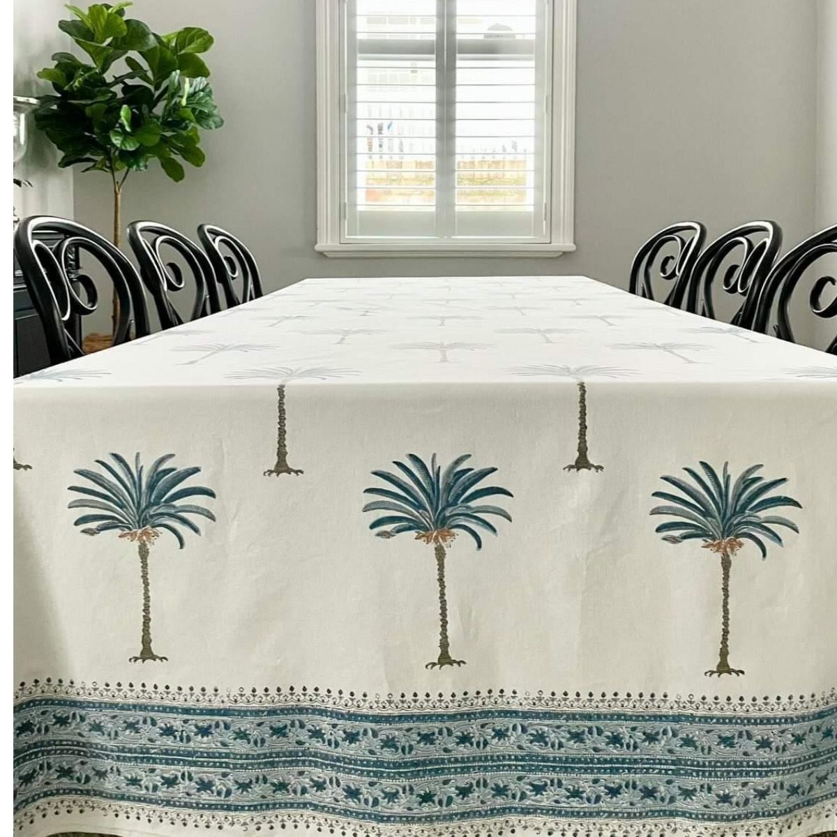 A hand block printed blue palm cotton tablecloth displayed on a large rectangular table