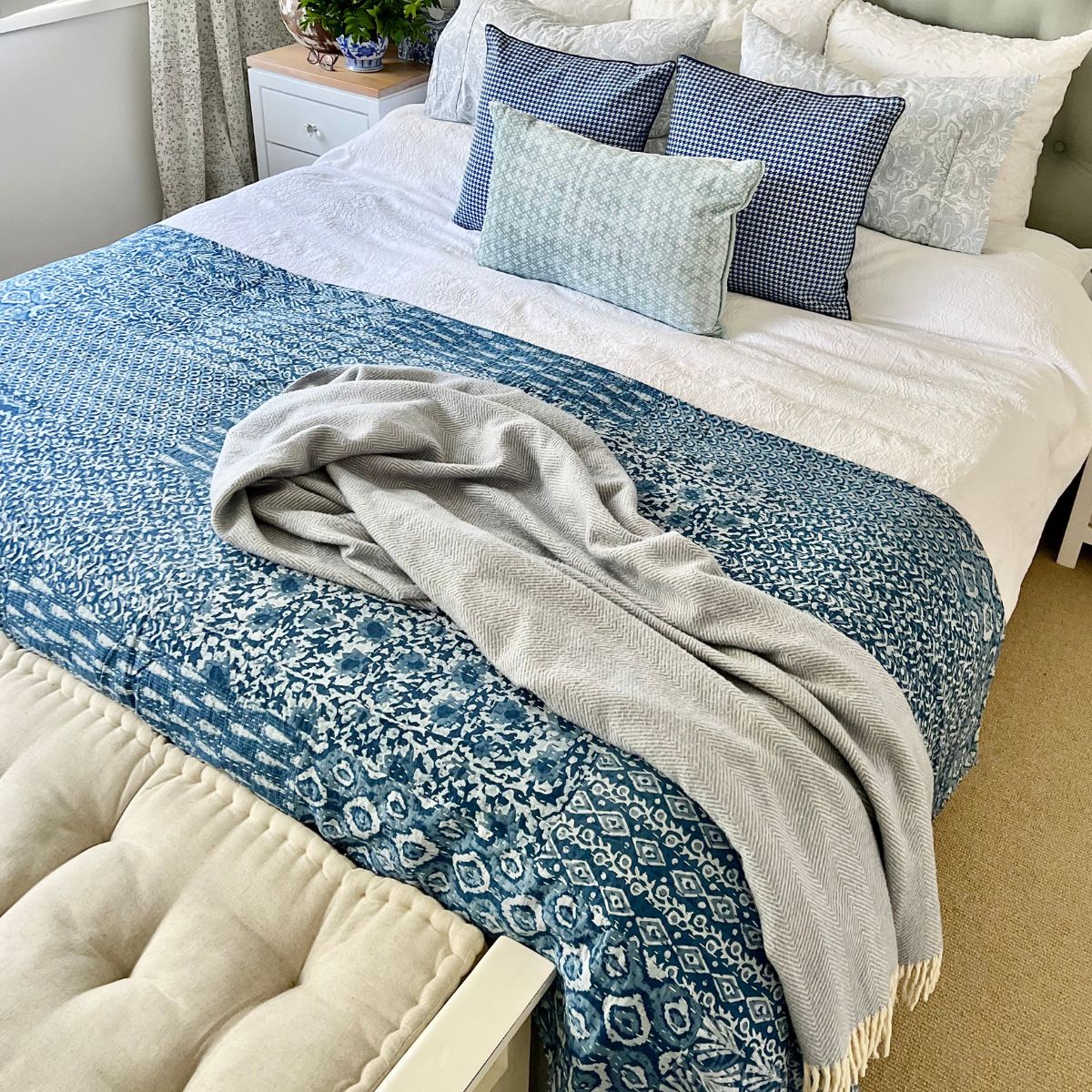 Lightweight blue and white patchwork Kantha quilt styled as a summer bed throw, showcasing timeless block print patterns and artisan craftsmanship.