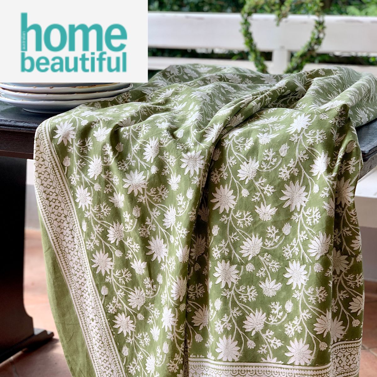 180 x 300 cm Flannel Flowers hand block printed tablecloth draped as featured in Home beautiful Australia magazine,  over a dining table, highlighting the premium cotton weight and elegant fabric flow.
