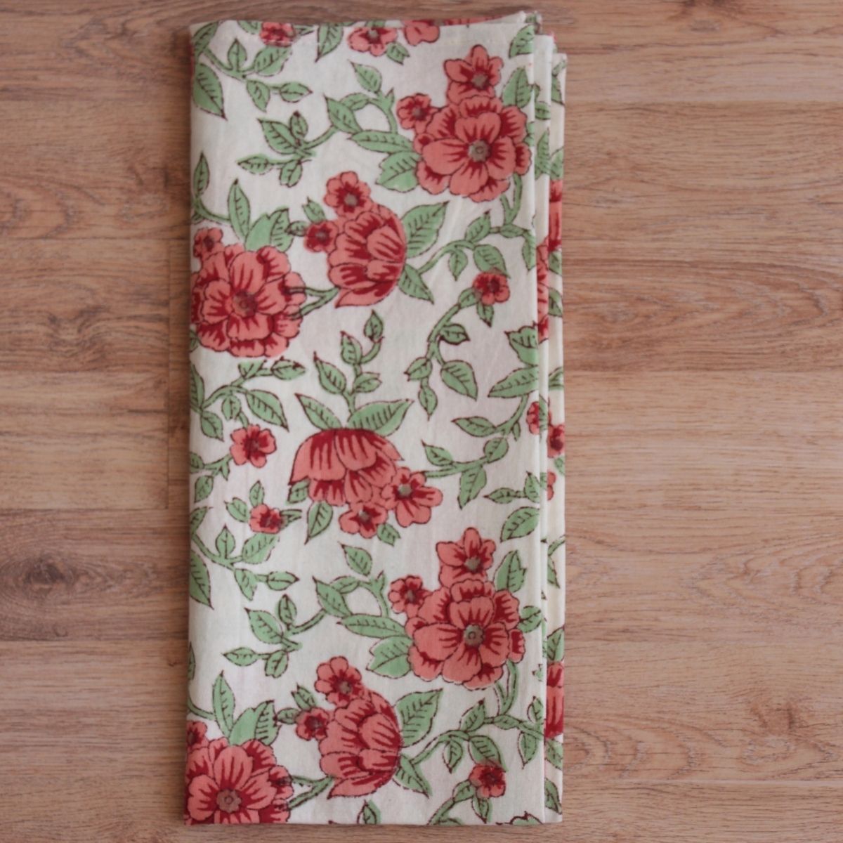 
Folded Florence cotton napkin featuring pink and green floral block print motifs, displayed on a neutral background to highlight artisan craftsmanship and generous 50 x 50 cm size.