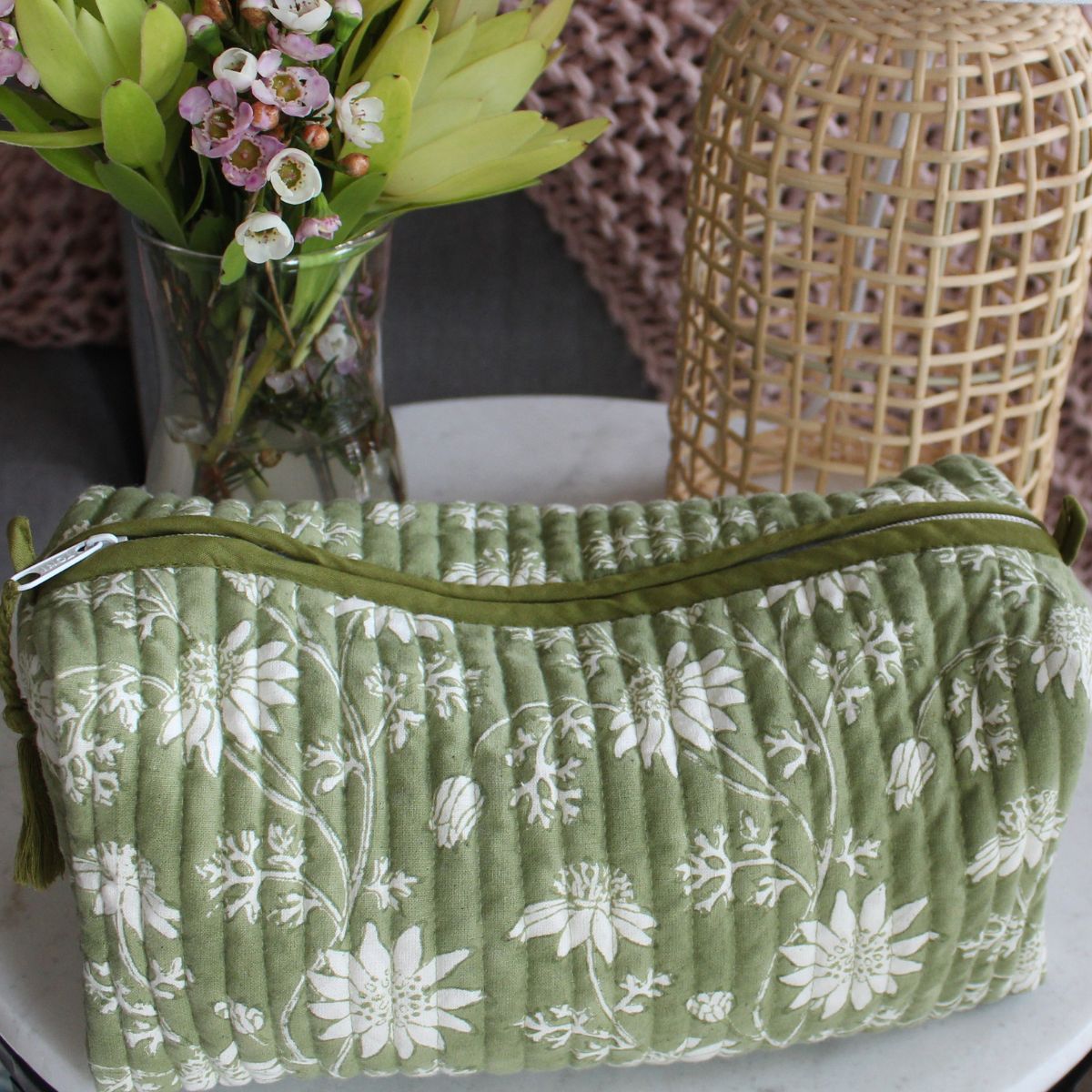 Flannel Flowers quilted cotton wash bag styled on a table, showcasing premium craftsmanship and practical storage for cosmetics and travel essentials.