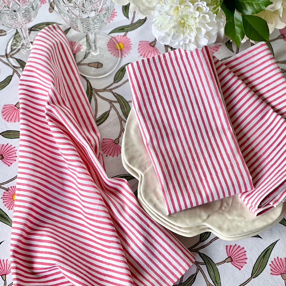 Machine washable cotton napkins with classic pink stripe block print design, styled on a floral tablecloth for relaxed dining and entertaining.