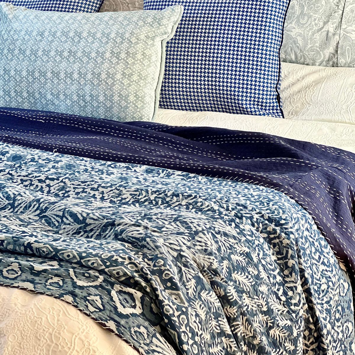 
Handcrafted blue and white patchwork Kantha bedspread made from repurposed block print cotton fabrics, creating a one-of-a-kind and sustainable bedroom accent.