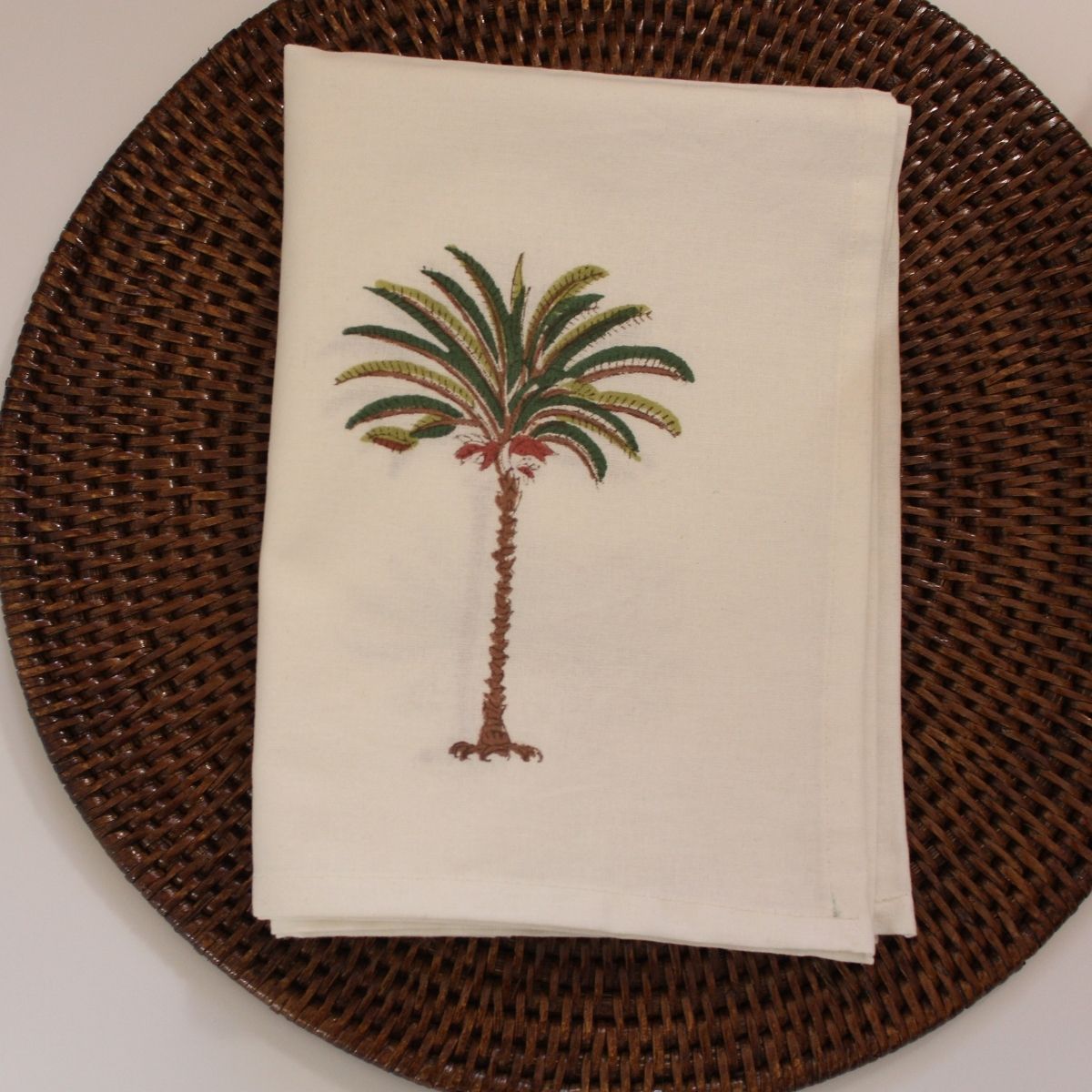 A hand block printed cotton napkin set in coastal palm tree design.