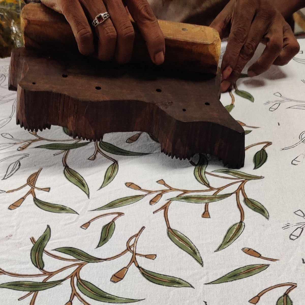 Indian artisan hand printing the Yellow Flowering Gums square tablecloth using traditional wooden blocks and handcrafted techniques.