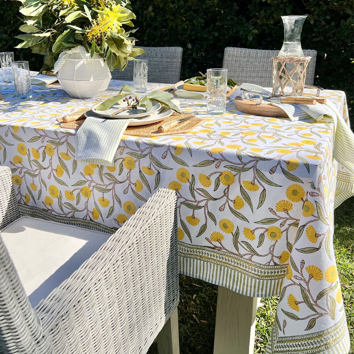 Green striped cotton napkins showcased on a 220 cm Yellow Flowering Gums square tablecloth during an outdoor lunch gathering.